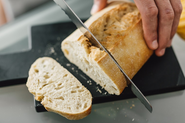 chef-cutting-fresh-italian-bread-WV62X7T